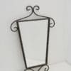 Stylish triangular wall mirror with twisted wrought iron frame, perfect for any elegant décor.