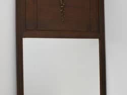 Elegant antique wooden mirror with floral carvings, enhancing vintage charm in any room.