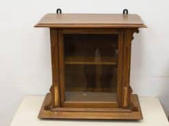 Elegant wooden display cabinet with glass doors, ideal for showcasing collectibles and decorative items.