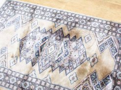 Vintage geometric rug in soft beige and blue, featuring intricate diamond patterns and timeless elegance.