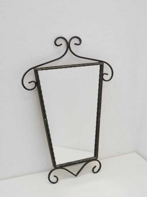 Elegant mirror with ornate wrought iron frame, perfect for enhancing any stylish interior.