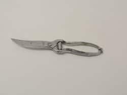 Vintage shiny metal scissors with curved blade, ideal for crafting and sewing tasks.