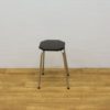 Stylish black octagonal stool with chrome legs, ideal for contemporary interiors and versatile spaces.