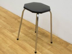 Stylish octagonal stool with chrome legs and a sleek black seat for modern interiors.