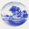 Serene blue landscape plate with thatched cottage, trees, and waterway, perfect for collectors.