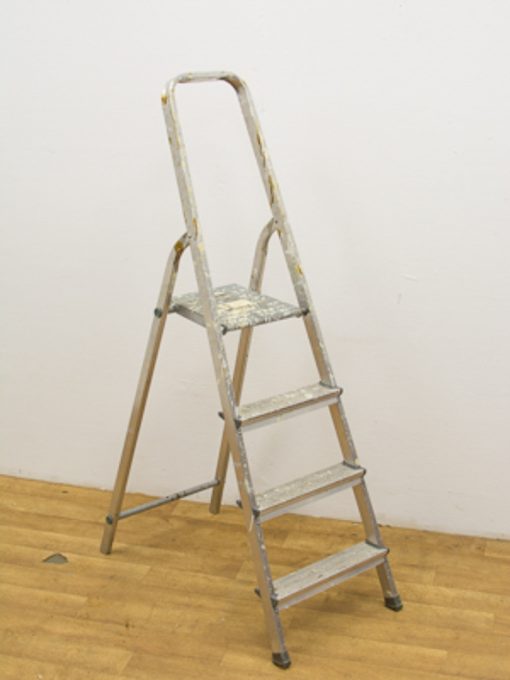 Vintage aluminum step ladder with wear, ideal for household tasks and painting projects.