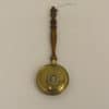 Elegant vintage brass skimmer with wooden handle, perfect for stylish kitchen serving and decor.