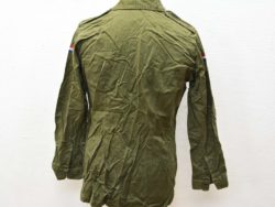 Vintage olive green military jacket with colorful patches, perfect for casual outfits and collectors.