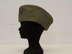 Vintage olive green military hat with gold emblem, ideal for collectors and history lovers.