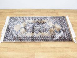 Antique diamond-pattern rug in warm tones, perfect for enhancing cozy interior decor.