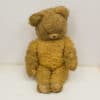 Vintage teddy bear in warm brown, evoking nostalgia and comfort through its well-loved features.