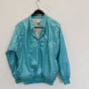 Retro turquoise Puma jacket from the 90s, featuring a half-zip and quilted sleeves.