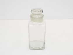 Sleek glass storage jar with lid, perfect for organizing and displaying vintage items stylishly.