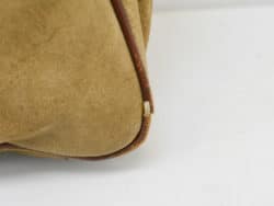 Vintage beige leather handbag with brown accents, featuring unique texture and timeless style.