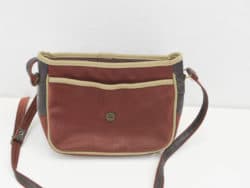 Chic reddish-brown handbag with tan trim and adjustable strap, perfect for stylish everyday use.