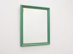 Vibrant green mirror with a sleek wooden frame, perfect for enhancing modern and retro interiors.