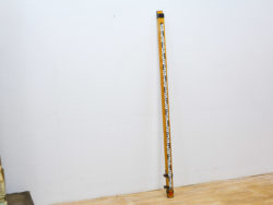 Bright yellow surveying rod for accurate measurements in construction and land surveying.