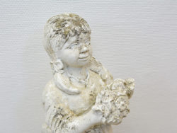 Charming vintage girl statue holding flowers, perfect for nostalgic home and garden decor.