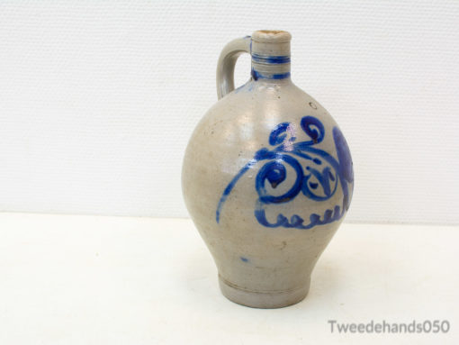 Handcrafted ceramic jug with intricate blue designs, ideal for rustic decor and functional use.