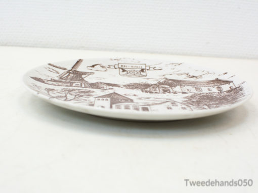 Charming vintage porcelain plate featuring a village landscape with a windmill for decor.