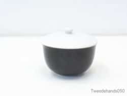 Elegant black and white bowl with lid, perfect for serving and stylish decor.