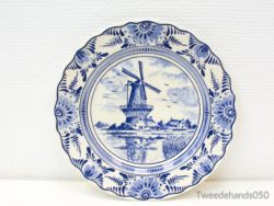 Elegant Delft plate with windmill and floral designs, embodying Dutch craftsmanship and heritage.