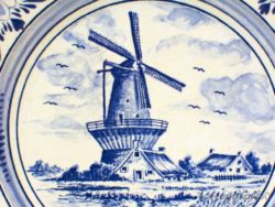 Traditional Dutch windmill surrounded by charming cottages and lush countryside greenery.