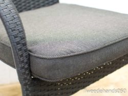 Elegant wicker chair with soft gray cushion, ideal for stylish indoor and outdoor seating.