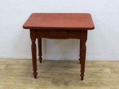 Charming vintage red table with drawer and elegant legs, perfect for cozy home decor.