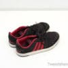 Worn black and red Adidas sneakers, combining style, comfort, and a story of adventures.