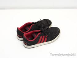 Worn black and red Adidas sneakers, combining style, comfort, and a story of adventures.