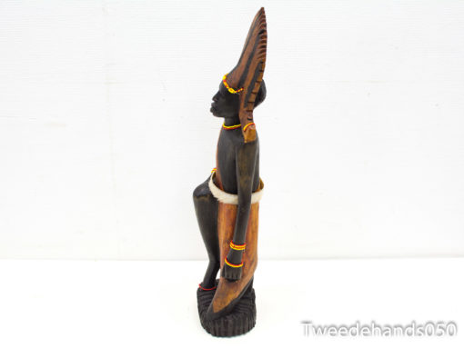 Elegant wooden sculpture of a female figure, showcasing intricate details and vibrant cultural adornments.