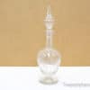 Elegant vintage glass decanter with ornate stopper, perfect for serving or stylish decor.