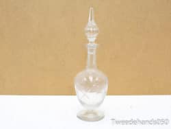 Elegant vintage glass decanter with ornate stopper, perfect for serving or stylish decor.