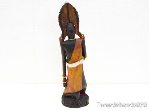 Intricately carved wooden sculpture with ceremonial headdress, reflecting vibrant cultural heritage and craftsmanship.