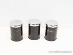 Chic black storage canisters with chrome lids, perfect for stylish organization in kitchens.