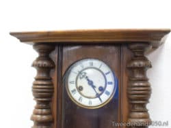 Antique wall clock with Roman numerals and intricate wood carvings, adding vintage elegance to interiors.