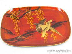 Elegant red tray featuring a graceful bird and vibrant floral decorations for stylish serving.