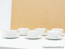 Elegant white porcelain tea cups with gold accents, perfect for stylish tea parties and gatherings.