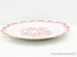 Elegant porcelain plate with red floral design and gold trim, ideal for collectors and decor.