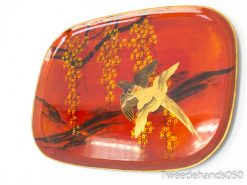 Stylish red decorative plate featuring a soaring bird and elegant yellow flowers.