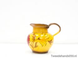 Charming yellow ceramic jug adorned with floral designs, perfect for decoration or serving.