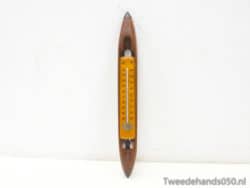 Vintage thermometer with yellow scale and elegant wooden frame for stylish retro decor.