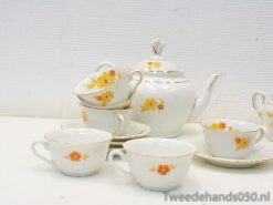 Charming vintage tea set with floral designs in yellow and orange, perfect for elegant gatherings.