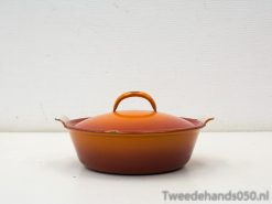 Vibrant orange ceramic casserole dish for cooking and stylish meal presentation.