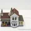 Charming miniature house with vibrant flowers and warm lighting for nostalgic decor.