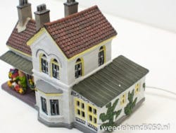 Charming miniature house with vibrant garden, classic design, perfect for decor and collectors.