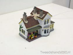 Enchanting miniature cottage with vibrant flowers, ideal for nostalgic home decoration and ambiance.