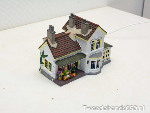 Enchanting miniature cottage with vibrant flowers, ideal for nostalgic home decoration and ambiance.