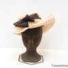 Elegant beige hat with luxurious dark brown bow, ideal for weddings and special occasions.